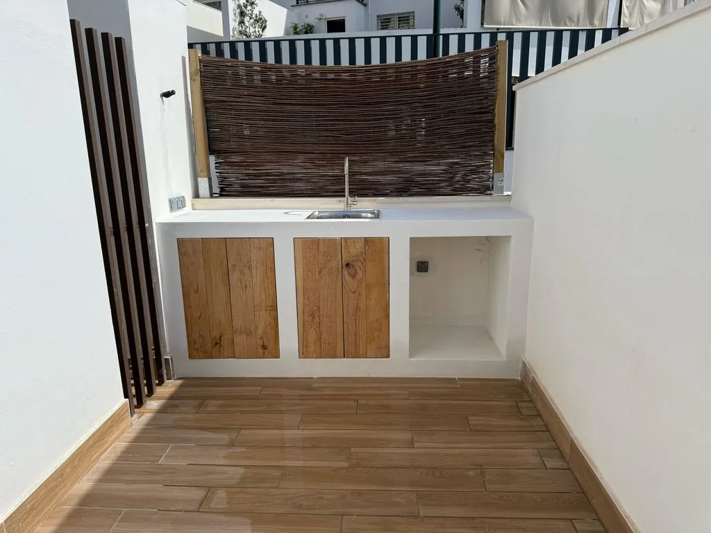 Buitenkeuken met gootsteen en houten deurtjes