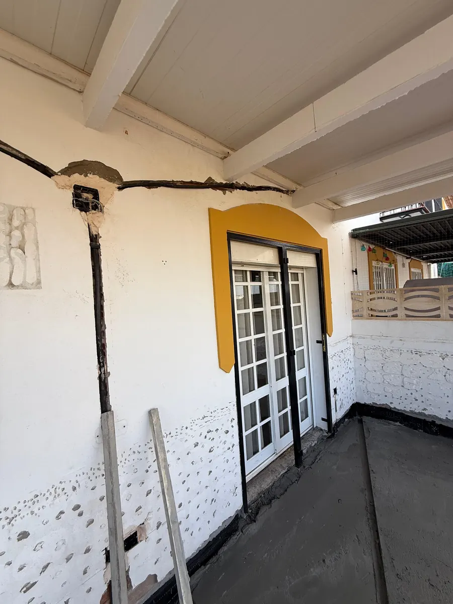 Dakterras voor de renovatie, met oude vloer en muren